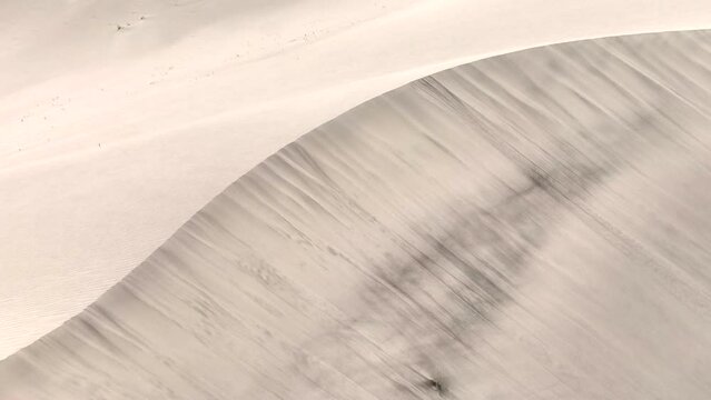 Scenic aerial view drone view flying over sand dunes Sarfaranga Cold Desert, Surrounding with Snow Cap Mountain in Skardu, Northern Pakistan