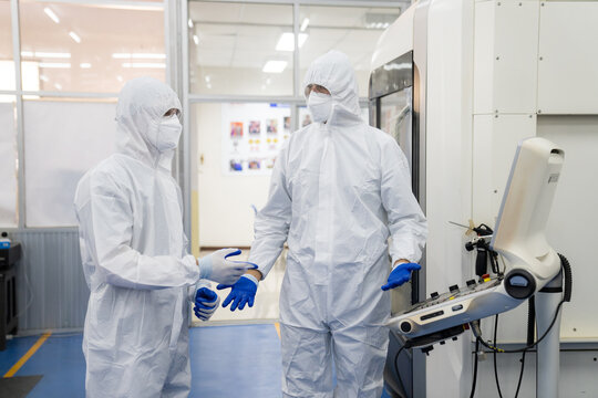 Professional Heavy Industry Robotics Engineer Wearing White Coat Holding Tablet Computer Works in Laboratory. Facility Full of Computers, control robot.