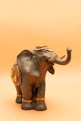 Fototapeta premium Template World Elephant Day. Bronze Decorated Elephant On Peach Yellow Background. Copy Space For Text. Ganesha Chaturthi Holiday. Sacred Symbol In Hindu, Buddhist Religions. Design, Vertical Plane.