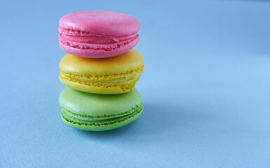 Colorful macaroons on blue background. Close up. Copy space.