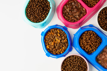 Plastic pet bowls with food isolated on white background