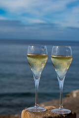 Pouring a glass of champagne on vacation, south of Fuerteventura, Canary islands, blue ocean, mountains