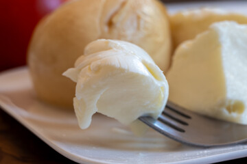 Tasty Italian food, small balls of white and smoked mozzarella soft cheese close up