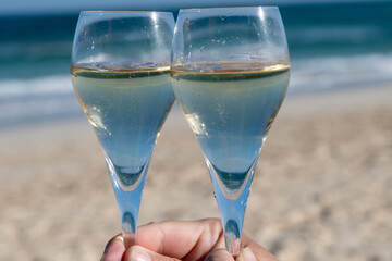 Pouring a glass of champagne on vacation, south of Fuerteventura, Canary islands, blue ocean, mountains