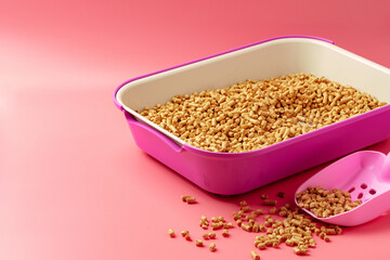 Pet litter box with bio filler on pink background