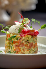 Salad with mayonnaise, chicken, peas, carrots and poached egg. A modern take on Ukrainian salad Olivier