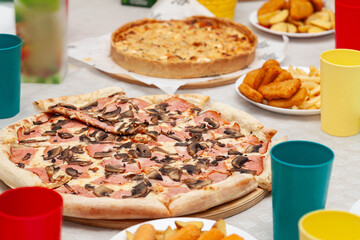 close-up of italian pizza with sausage and mushrooms on the festive table during a party