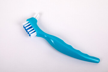 Denture toothbrush on a white background. Effective cleaning of teeth and gums
