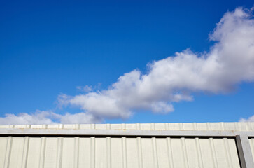 Corrugated steel fence against blue sky. Corrugated metal texture surface or galvanize steel