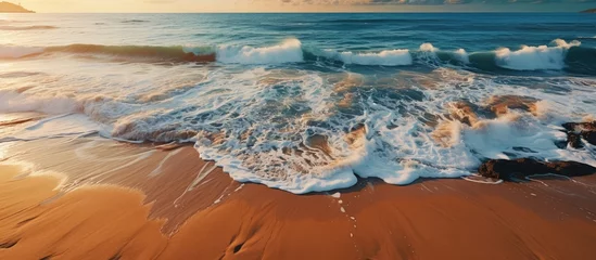 Fototapeten Aerial view of sandy beach at sunset © MBRAMO