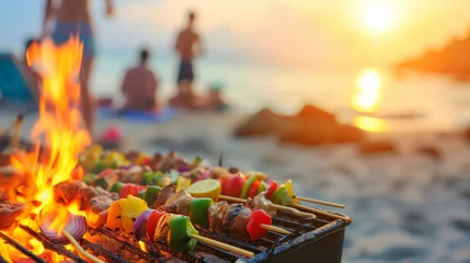  Summer bbq concept image with skewers on a hot barbecue on the beach with people in background © Keitma