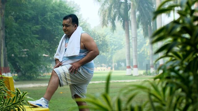 Indian middle aged overweight man stretching his body - fitness  obese  obesity  stiff body  weight loss regime . Man doing warm up early in the morning-exercise  body fat  extra fat  chubby  worko...