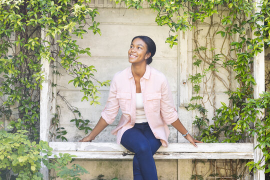 Young biracial woman enjoys a moment outdoors, with copy space