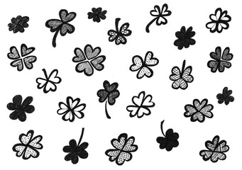 Set of clovers in doodle style. Black color on a white background. Shamrocks or four leaf clovers. Filling or contour drawing with decor. Decor of lines, dots, strokes, wavy lines and other ornaments.
