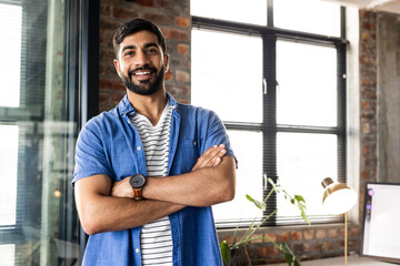 Confident businessman in casual business attire stands in a modern office