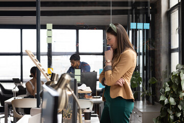 Young Caucasian woman contemplates a casual business project in the office