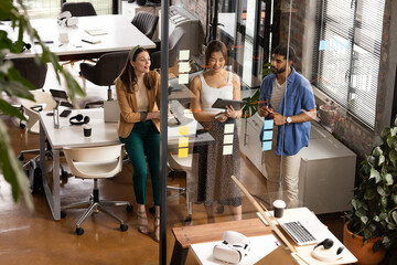 Young Asian man and women engage in casual business discussions in a modern office
