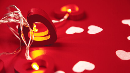 Composition for Valentine's Day. Heart shaped garland on a red background. Copy space