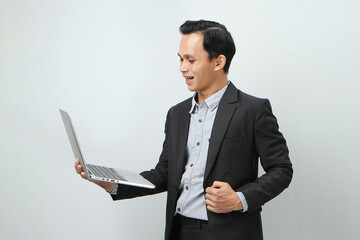 Happy asian indonesian business man in suit holding laptop computer on isolated background