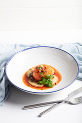 Buckwheat and meat patty braised in tomato-basil sauce, garnished with mushrooms and microgreens. Modern trendy cuisine, protein-packed grains. Concept of healthy eating.