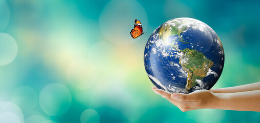Hand holding earth with butterfly over green blur background. Saving Planet, Protect green nature and ecology, Sustainable lifestyle. World Environment and Green concept. Elements furnished by NASA.