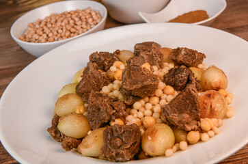 Moughrabieh is a popular dish in the Lebanese cuisine, LEBANESE RECIPE FOR MOUGHRABIEH WITH BEEF AND SMALL ONIONS, SEMOLINA PEARLS AND CHICKPEAS. High quality photo