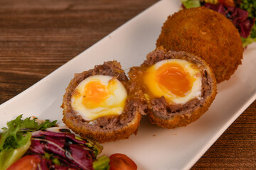 RECIPE FOR BREADED BEEF MEATBALLS STUFFED WITH A SOFT BOILED EGG. High quality photo