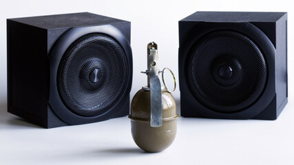 Hand grenade, next to two audio speakers. A metaphor for powerful sound or explosive audio and...