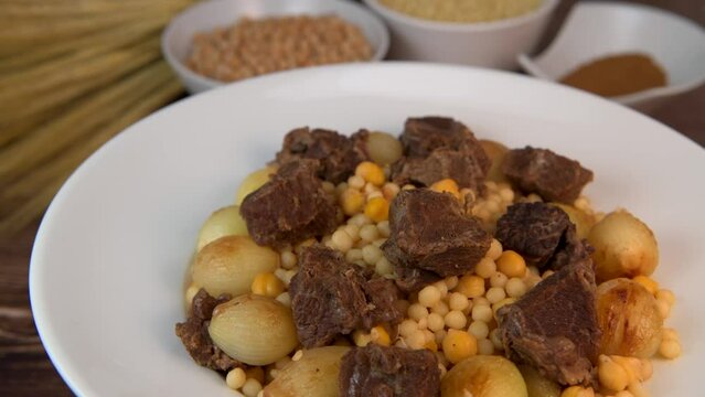 Moughrabieh is a popular dish in the Lebanese cuisine, LEBANESE RECIPE FOR MOUGHRABIEH WITH BEEF AND SMALL ONIONS, SEMOLINA PEARLS AND CHICKPEAS. High quality video