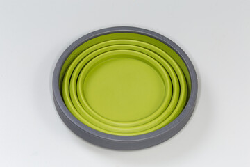 Tourist foldable silicone cup in folded state on  gray surface