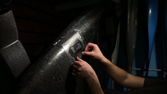 working with resin. stick on tape. canoe repair. vertical video. slow motion video. High quality video in 4K format.