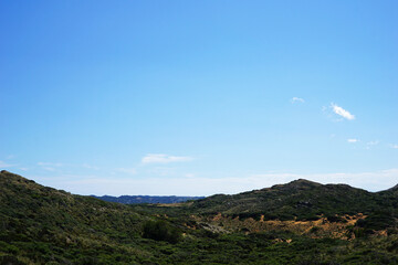 Fototapeta premium Natural landscape of Playa de Cavalleria (Mercadal) in Minorca beach with clear blue sky and rocky seashore- Menorca, Spain