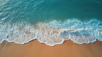An aerial view of an empty beach, with the waves gently lapping at the shore