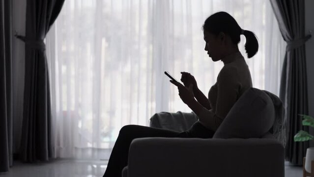 Silhouette of depressed woman sitting on the floor of an abandoned building Sad woman, Cry, drama, lonely and unhappy concept.