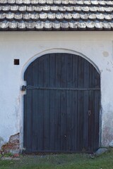 An old wooden door on a white stone wall.
