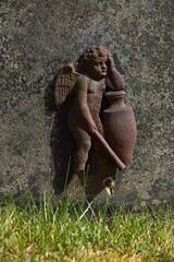 Closeup of a  headstone with sculpture of an angel.