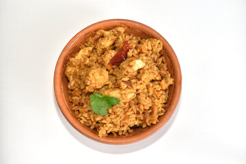 Rice with meat, pilaf, in a clay plate on a white background, top view.