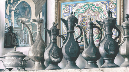 Old copper jugs stand at street antique market. Minochrome, toning. Bukhara, Uzbekistan - obrazy, fototapety, plakaty