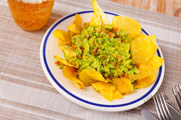Traditional mexican guacamole sauce with savory crispy chips