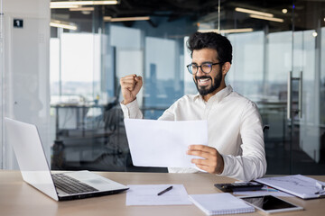 A white-collar worker on a desk with a laptop in an office building.