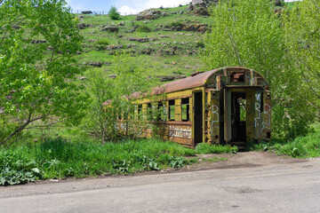 Old rusty railway wagon used as bridge over the river.
