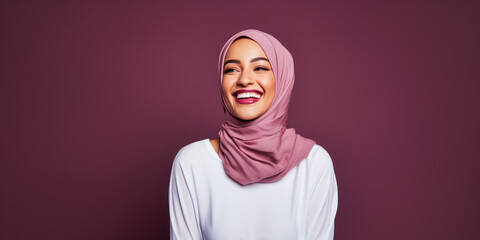 Muslim woman in mauve hijab laughing joyfully against deep maroon background. Happiness concept. Generative AI