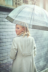 Woman, umbrella and walking with rain in city, thinking or ideas with cover, weather and memory in winter. Person, outdoor and road with travel, journey or commute with water on sidewalk in Cape Town