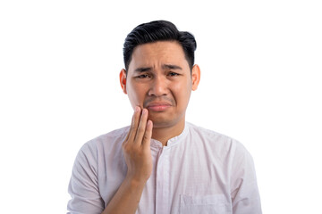 Fototapeta na wymiar Unhealthy Asian Muslim man suffering from acute toothache, touching cheek with painful expression isolated on white background. Ramadan and Eid Fitr celebration concept