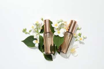 Jasmine flowers and perfume bottle on white background, top view