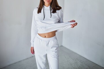 A young woman poses in a white hoodie for a mock-up template. A print and branding design concept....