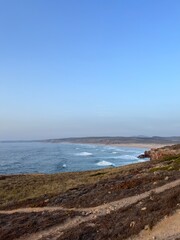 Rocky coast of the ocean bay, clear blue sky, ocean horizon, rocks