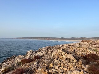Rocky coast of the ocean bay, clear blue sky, ocean horizon, rocks