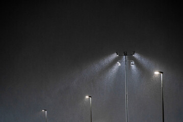 light in the night - lamp post and light beam in snow storm