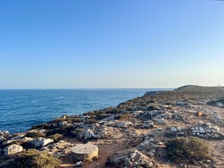Rocky coast of the ocean bay, clear blue sky, ocean horizon, rocks